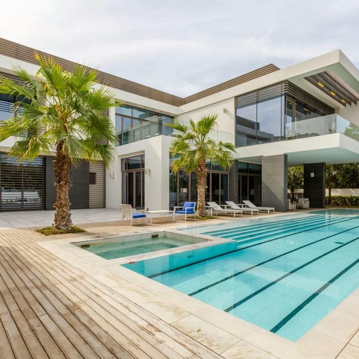 Explore this luxurious modern villa in Dubai with a stunning swimming pool and palm trees.